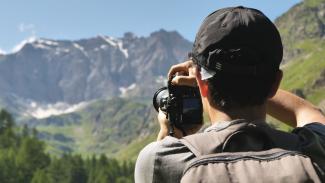 ragazzo che fotografa montagna